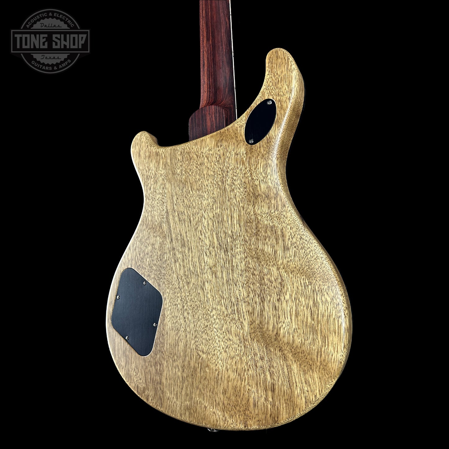 Wooden guitar body with a dark finish on a black background, featuring the Tone Shop logo.