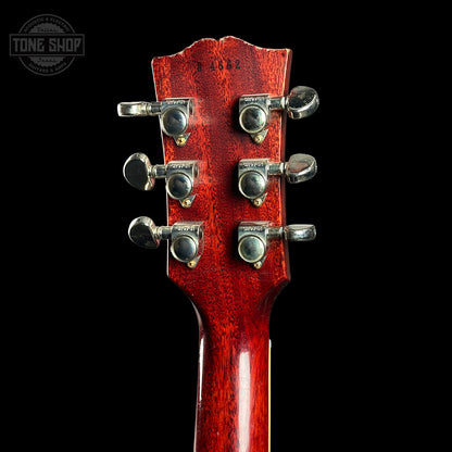 Close-up of a red guitar headstock with tuning pegs on a black background, featuring 'Tone Shop' logo.