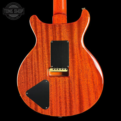 Back view of a wooden electric guitar with 'Tone Shop' logo.