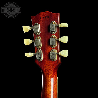 Close-up of a guitar headstock with tuning pegs on a black background, featuring the Tone Shop logo.
