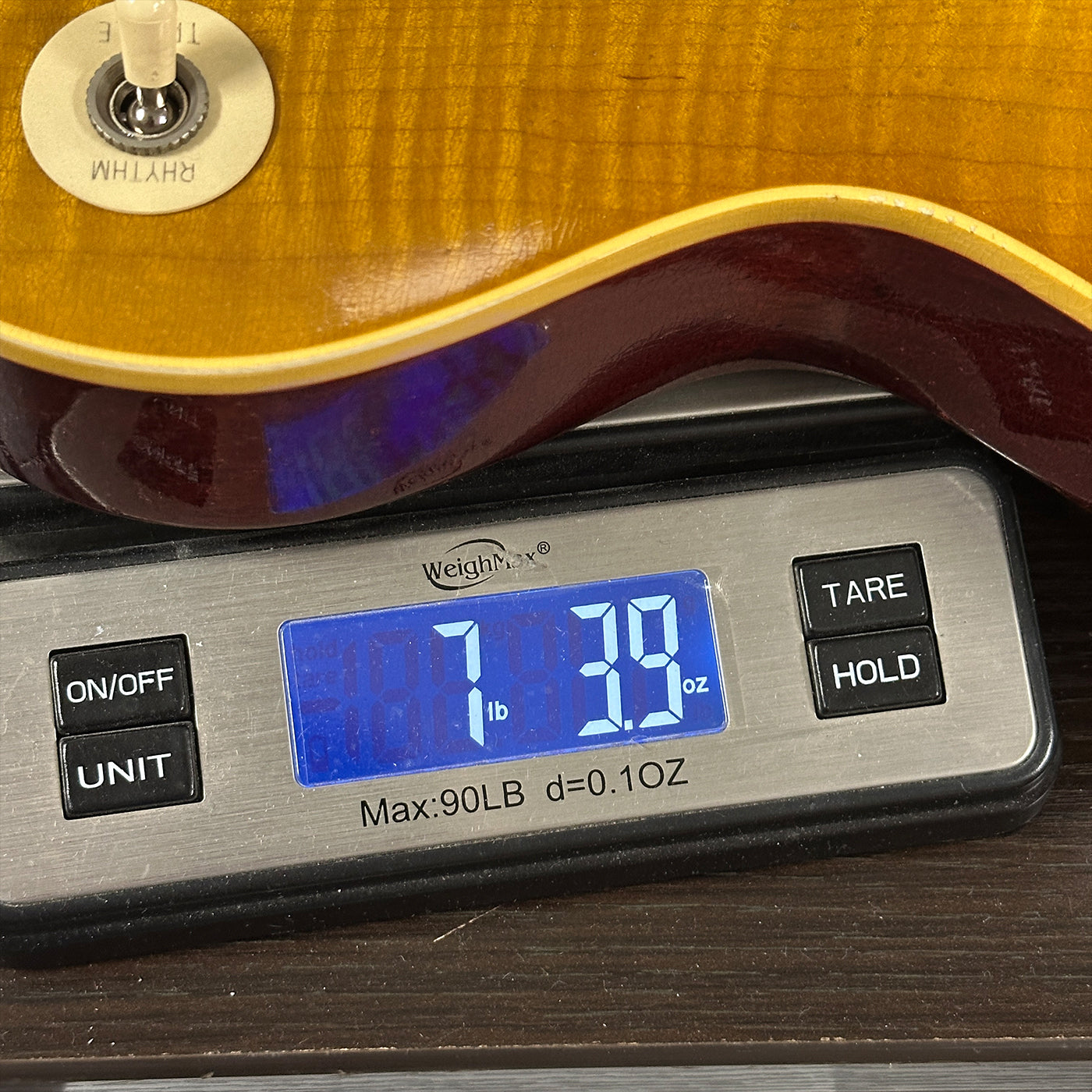 Guitar on a digital scale displaying weight
