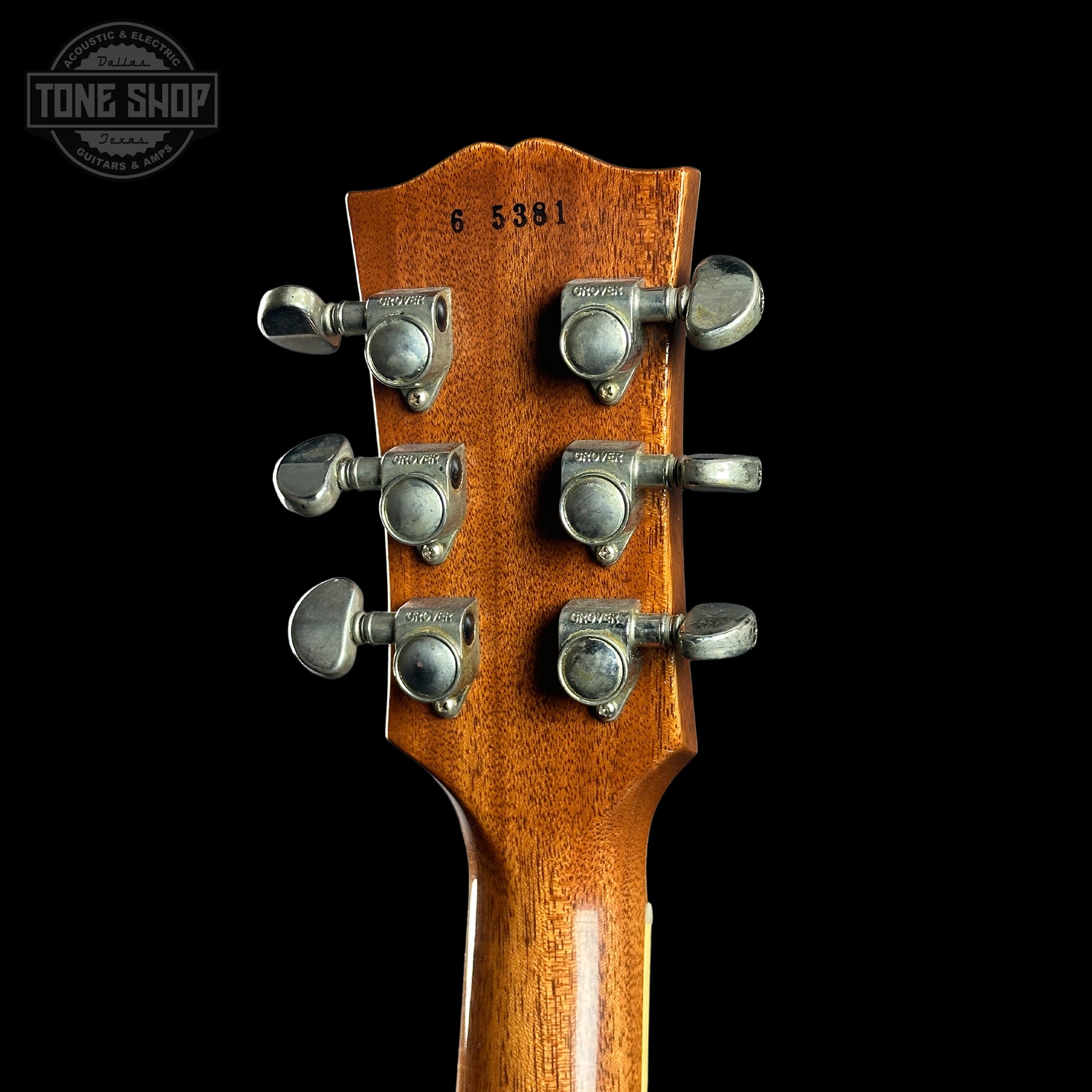 Guitar headstock with tuning pegs on a black background, featuring 'Tone Shop' logo.