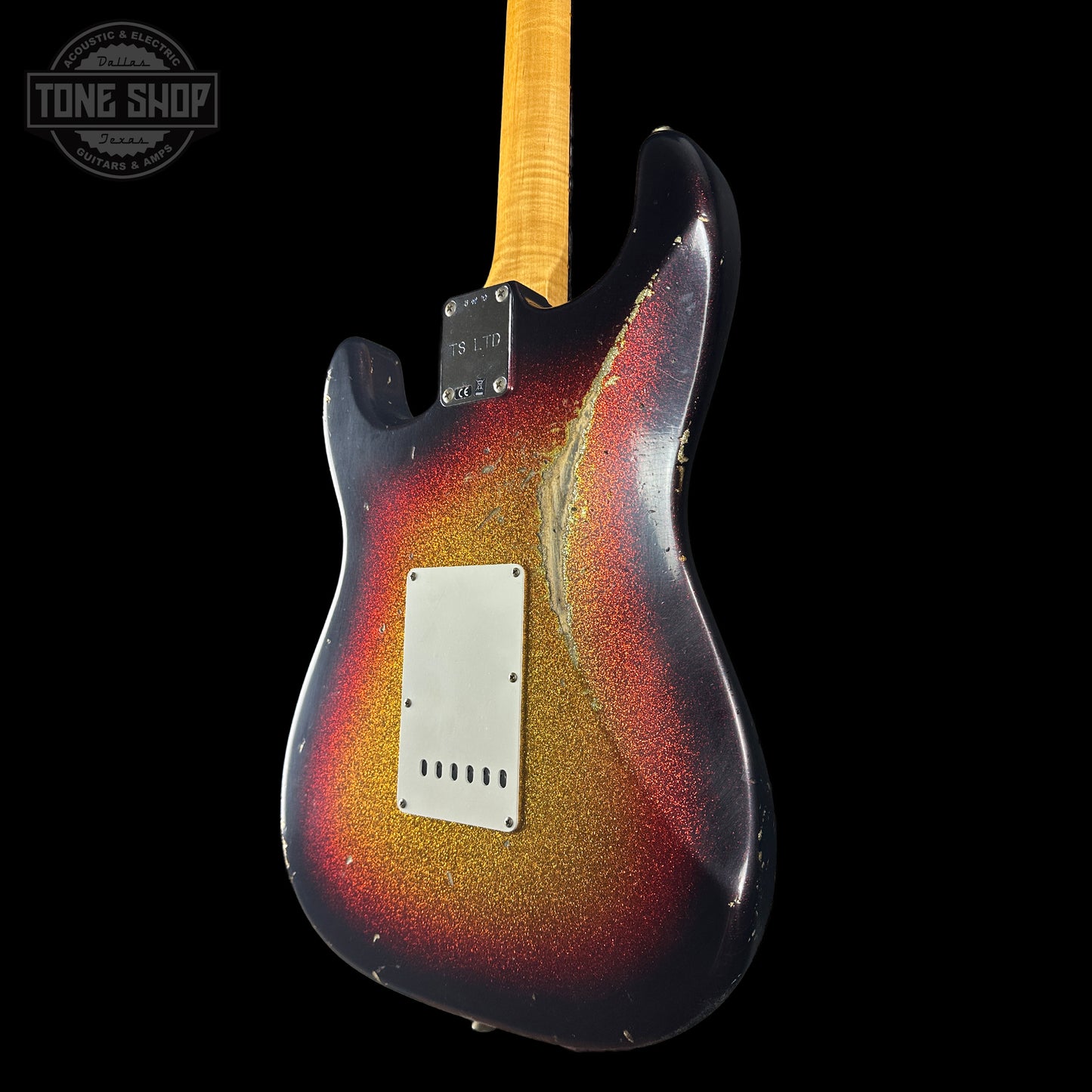 Guitar with a multicolored glitter finish on a black background, featuring the Tone Shop logo.