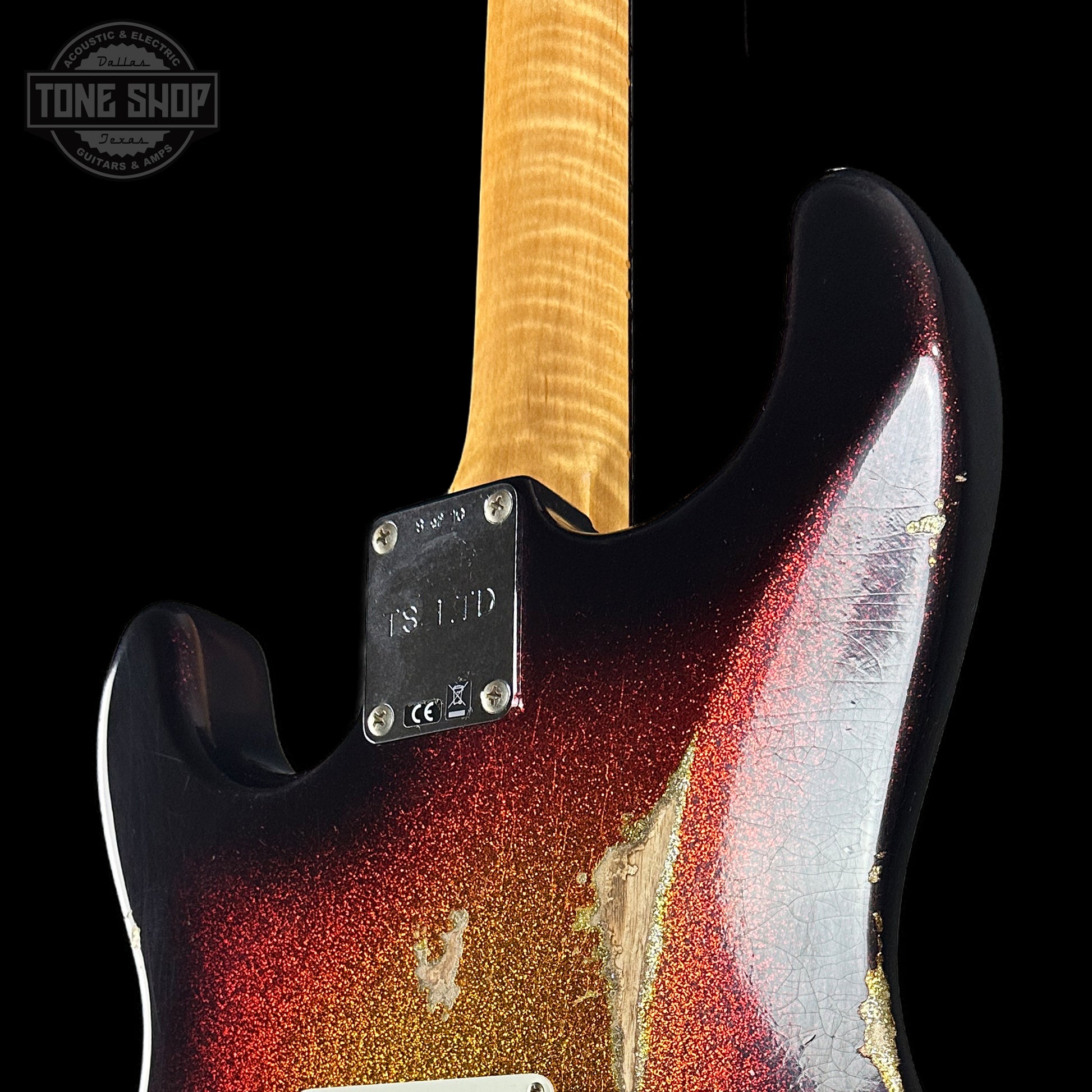 Close-up of a guitar with a red and white finish, brand logo visible.