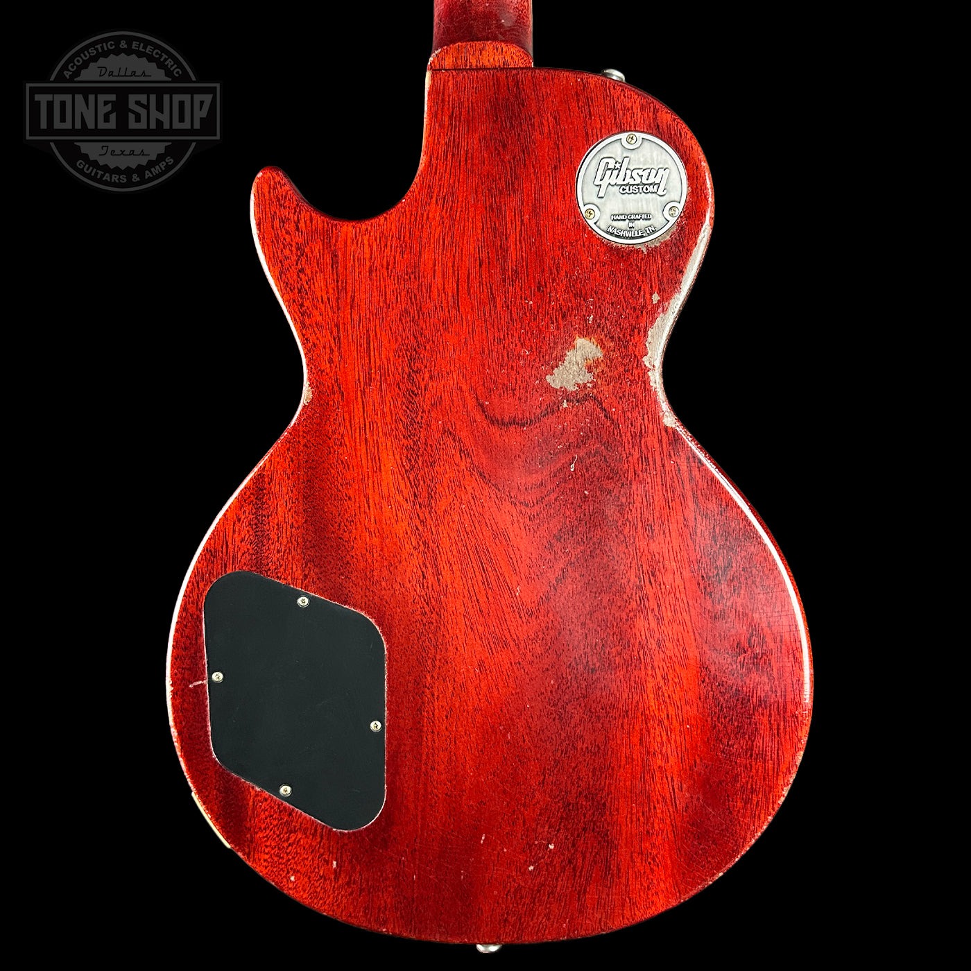 Red electric guitar body with a visible brand logo on a black background