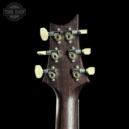 Close-up of a guitar headstock with tuning pegs on a black background, featuring the Tone Shop logo.