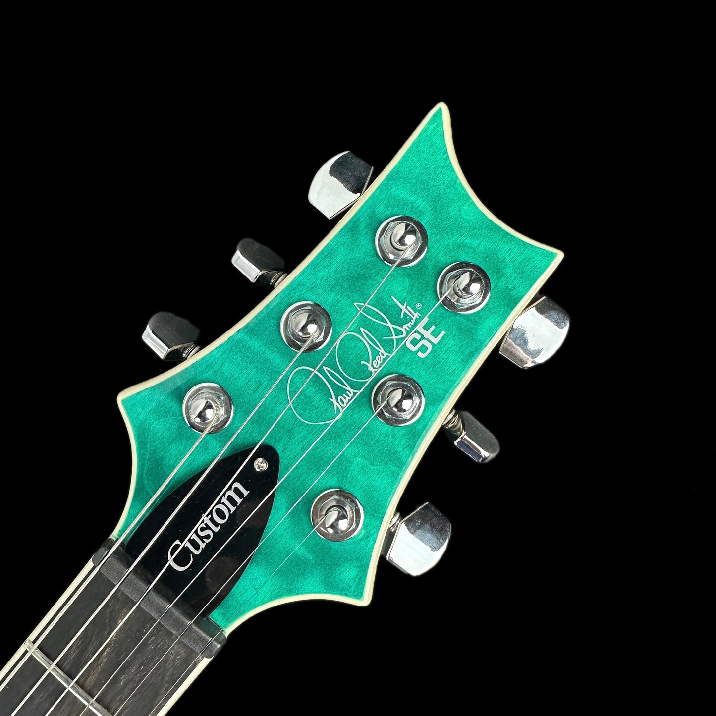 Front of headstock of PRS Paul Reed Smith SE Custom 24 Quilt Top Turquoise.
