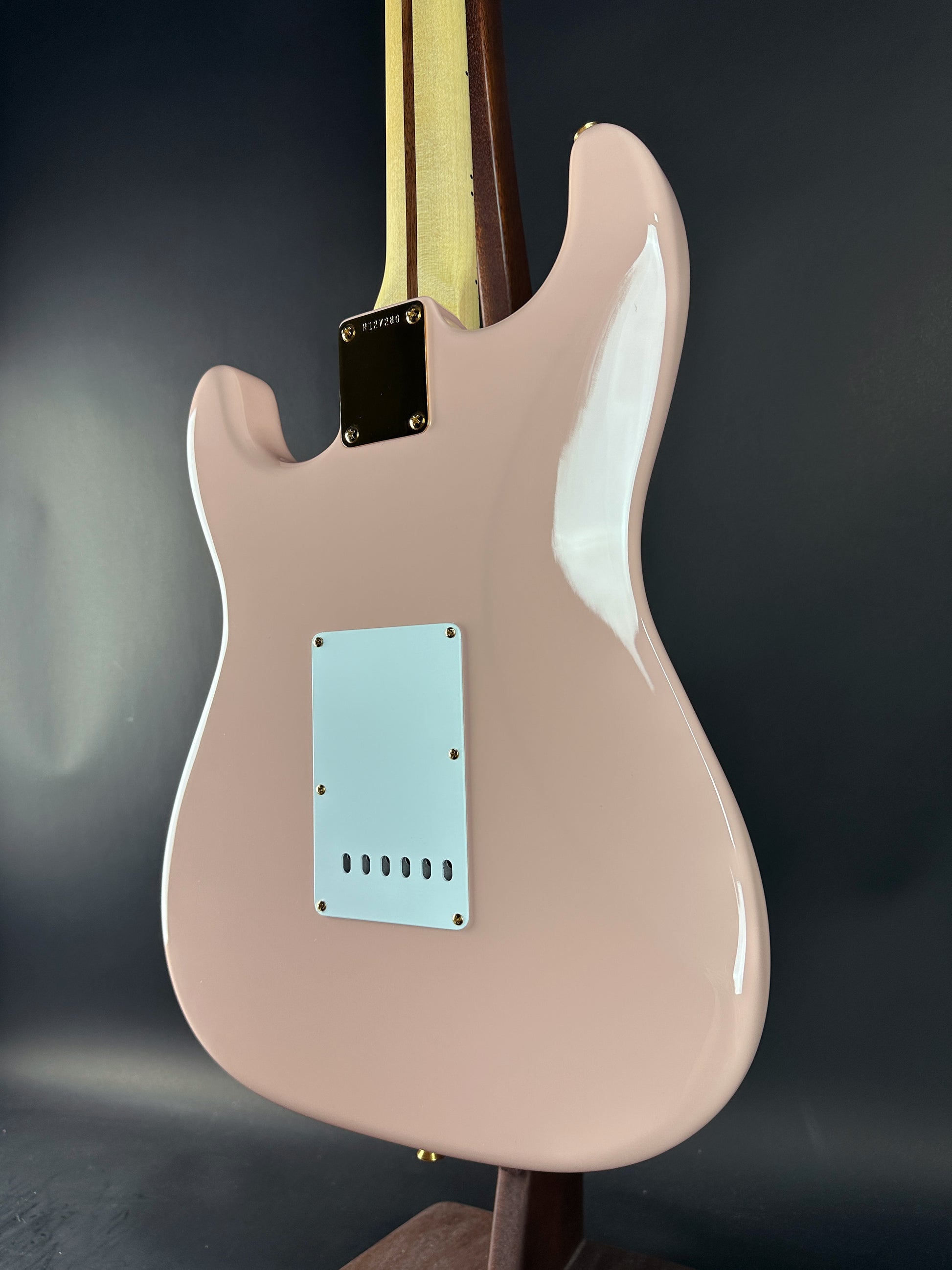 Pink electric guitar on a dark background