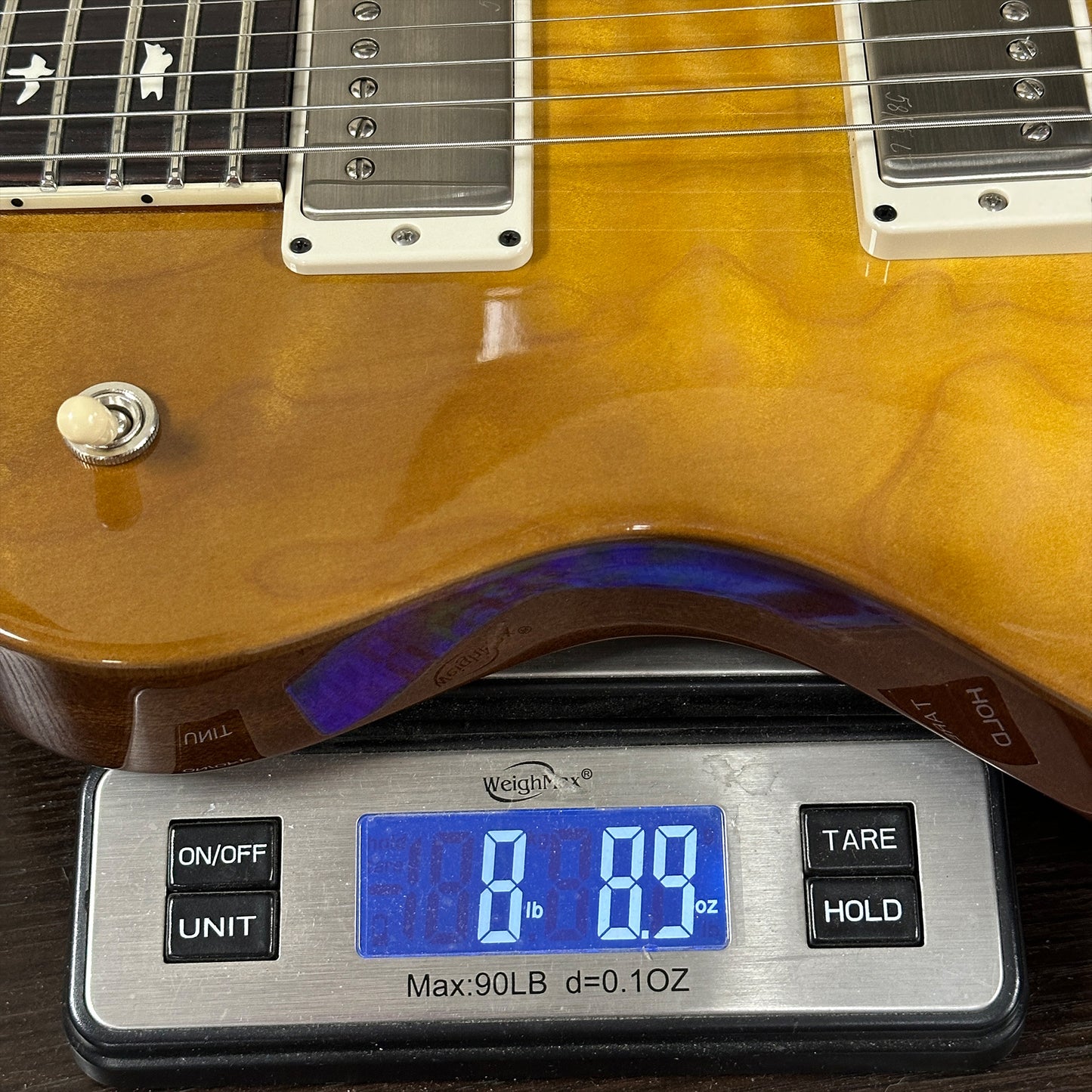 Guitar on a digital scale displaying weight