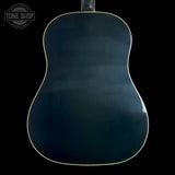 The back of an acoustic guitar with a glossy dark blue-green finish and a thin light-colored edge trim, shown against a solid black background.