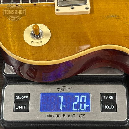 Electric guitar on a digital scale with 'Tone Shop' branding.