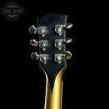 Guitar headstock with tuning pegs on a black background, featuring the Tone Shop logo.
