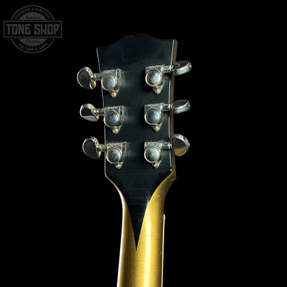 Guitar headstock with tuning pegs on a black background, featuring the Tone Shop logo.
