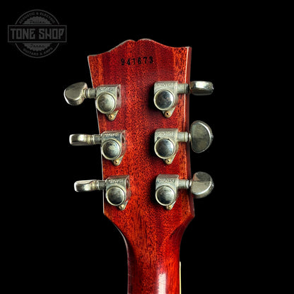 Close-up of a red guitar headstock with tuning pegs on a black background, featuring 'Tone Shop' branding.