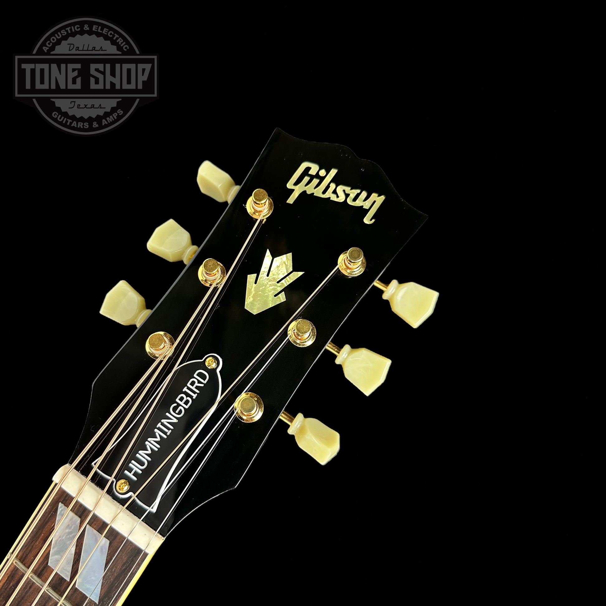 Front of headstock of Gibson Custom Shop M2M Hummingbird Original Ebony Gold HW.