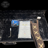 Guitar case with Fender strap, accessories, and Tone Shop logo.