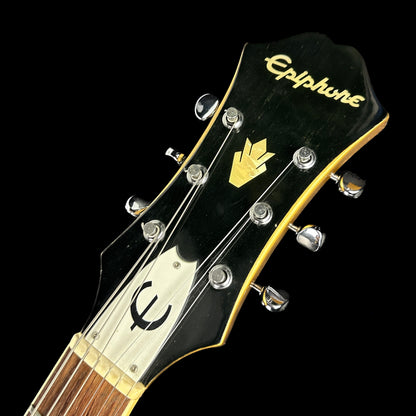Front of headstock of Used Epiphone Riviera w/bigsby Gold Sparkle.