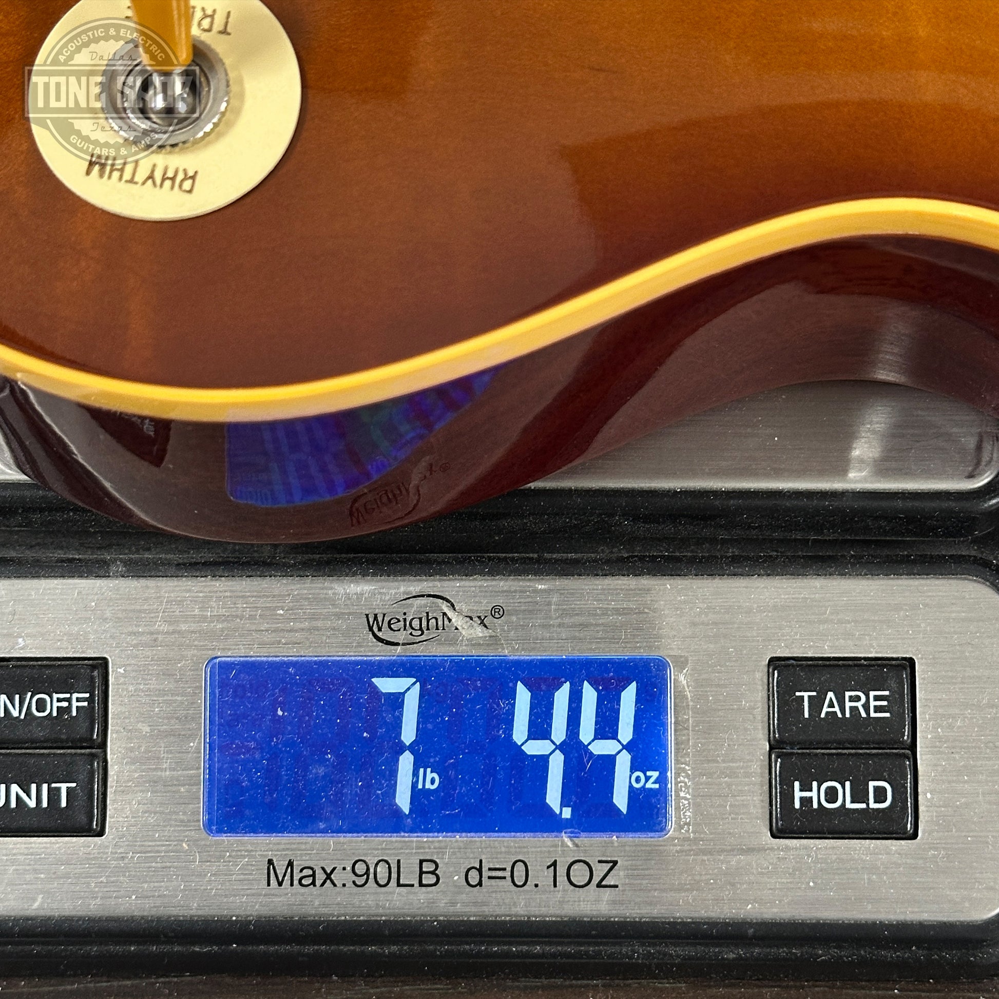 Guitar on a digital scale displaying weight