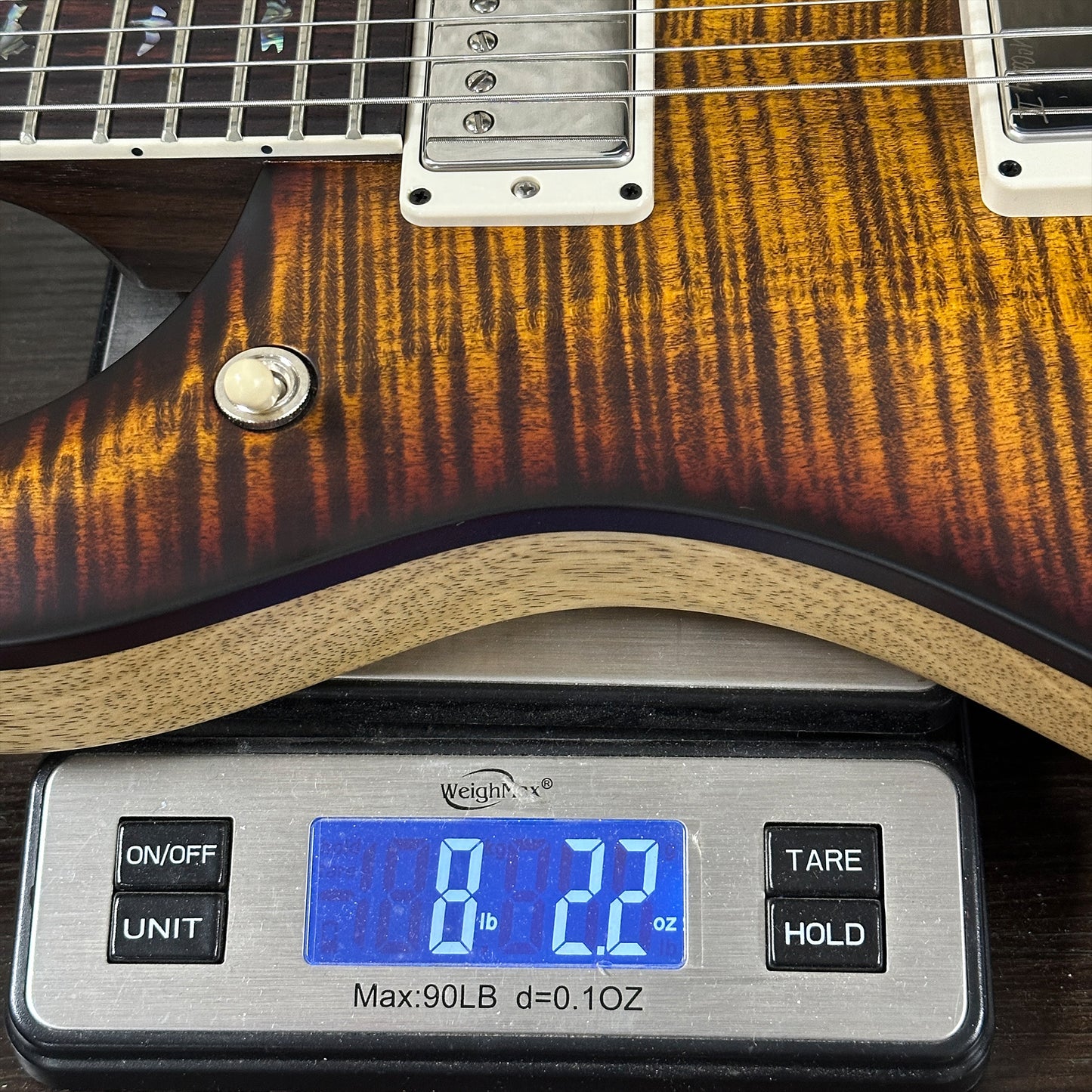Electric guitar on a digital scale displaying weight