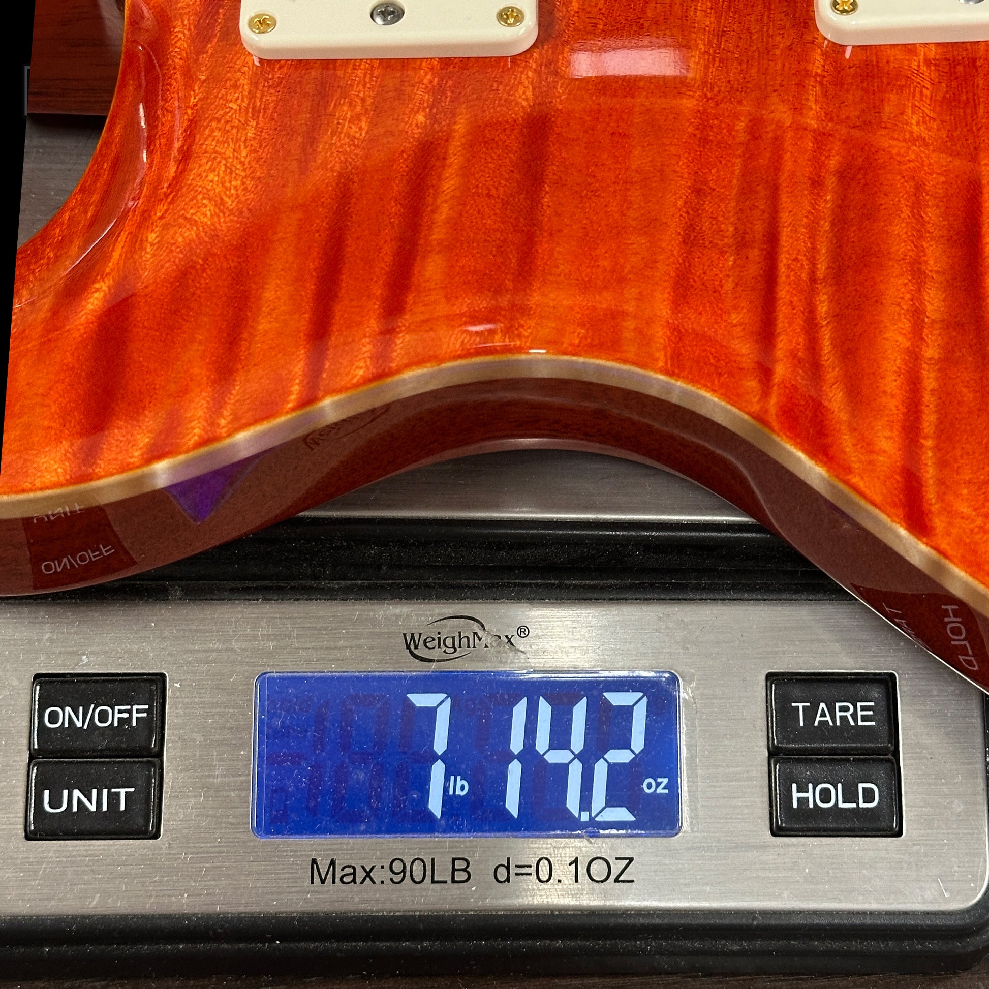 Guitar on a digital scale displaying weight
