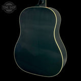 The back of an acoustic guitar with a glossy dark teal-green finish and a thin cream-colored edge trim, shown against a solid black background.