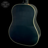 The back of an acoustic guitar with a glossy black finish and a thin cream-colored binding edge, shown against a solid black background.