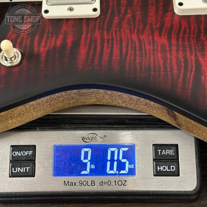 Guitar on a digital scale with 'Tone Shop' branding.