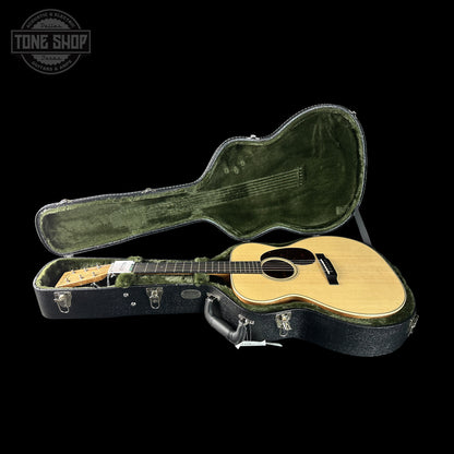 Acoustic guitar in a hard-shell case with 'Tone Shop' logo in the corner.