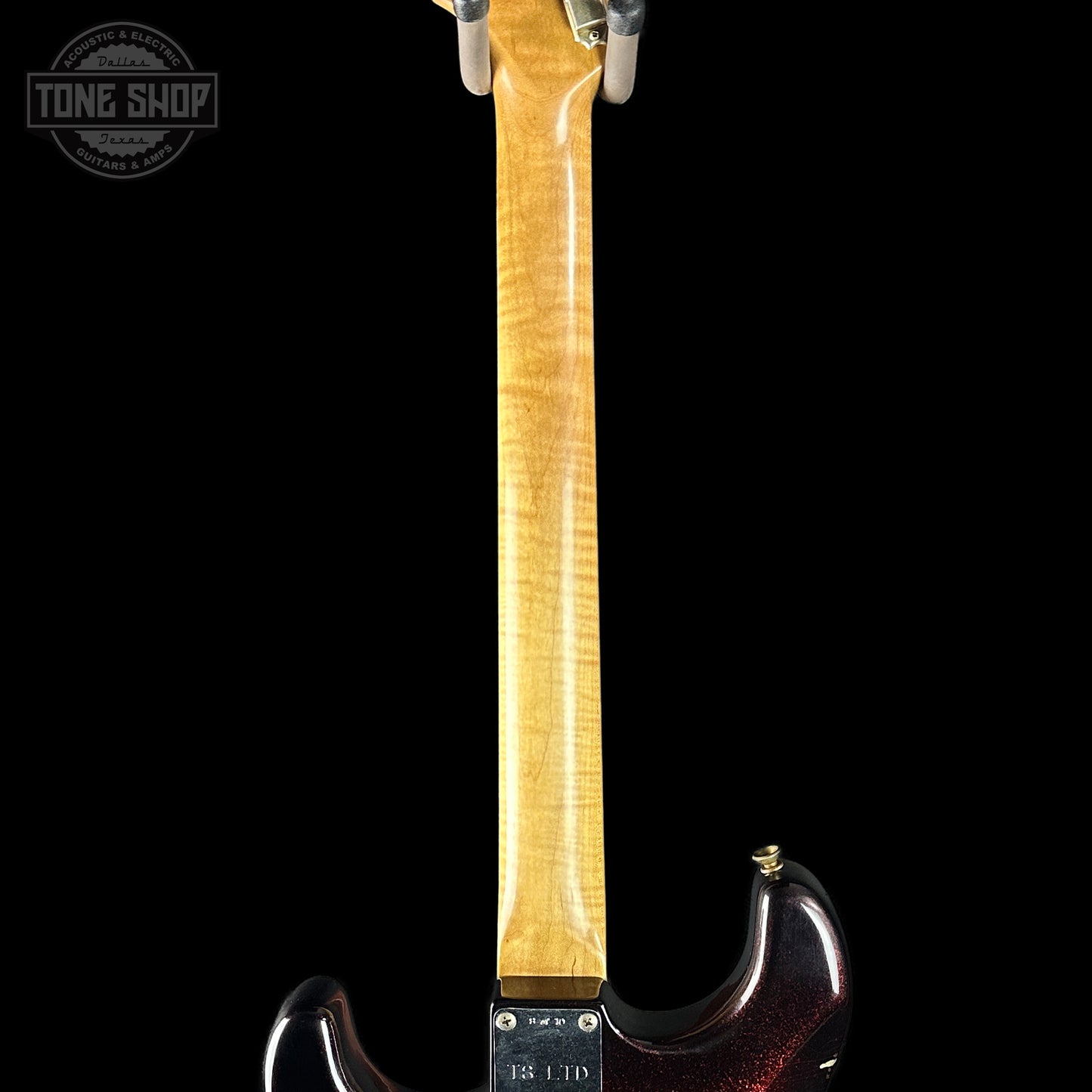 Guitar neck with a visible brand logo on a black background