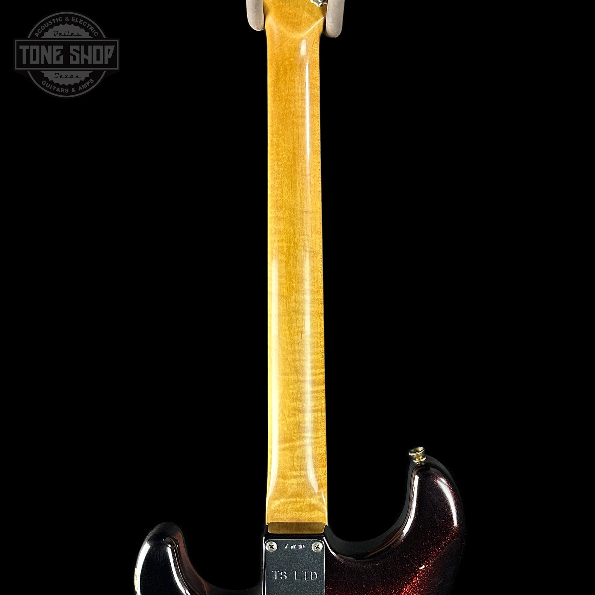 Guitar neck with a dark red body on a black background, featuring 'Tone Shop' branding.