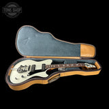 Electric guitar in an open case with 'Tone Shop' logo.