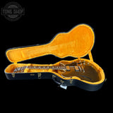 Electric guitar in an open case with 'Tone Shop' branding.