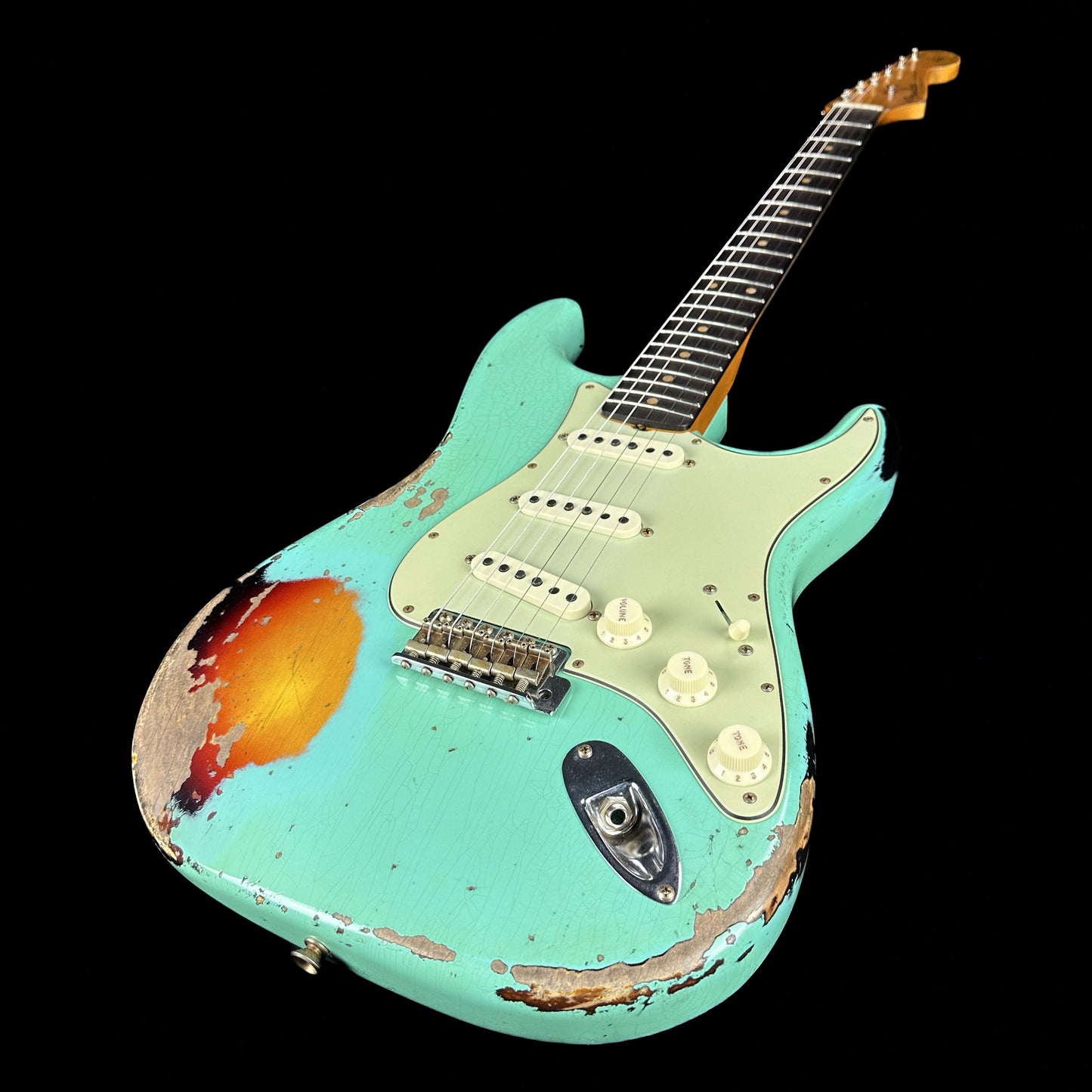 Front angle of Fender Custom Shop Limited Edition '62 Strat Heavy Relic Faded Aged Sea Foam Green Over 3 Color Sunburst.