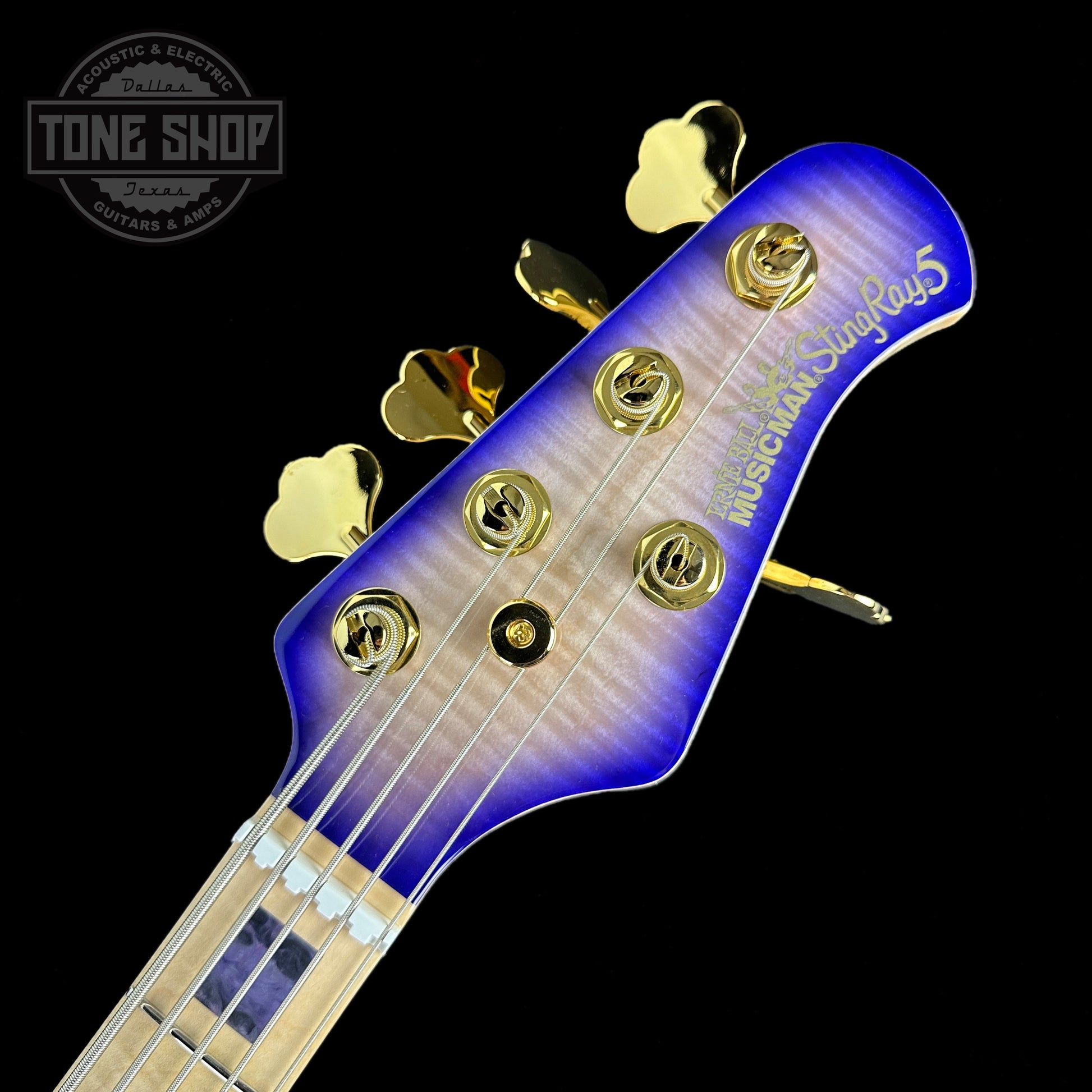 Front of headstock of Ernie Ball Music Man BFR "Moonbeam" StingRay Special 5 HH 5-String Bass Figured White Maple Fretboard Trans Purple Burst.