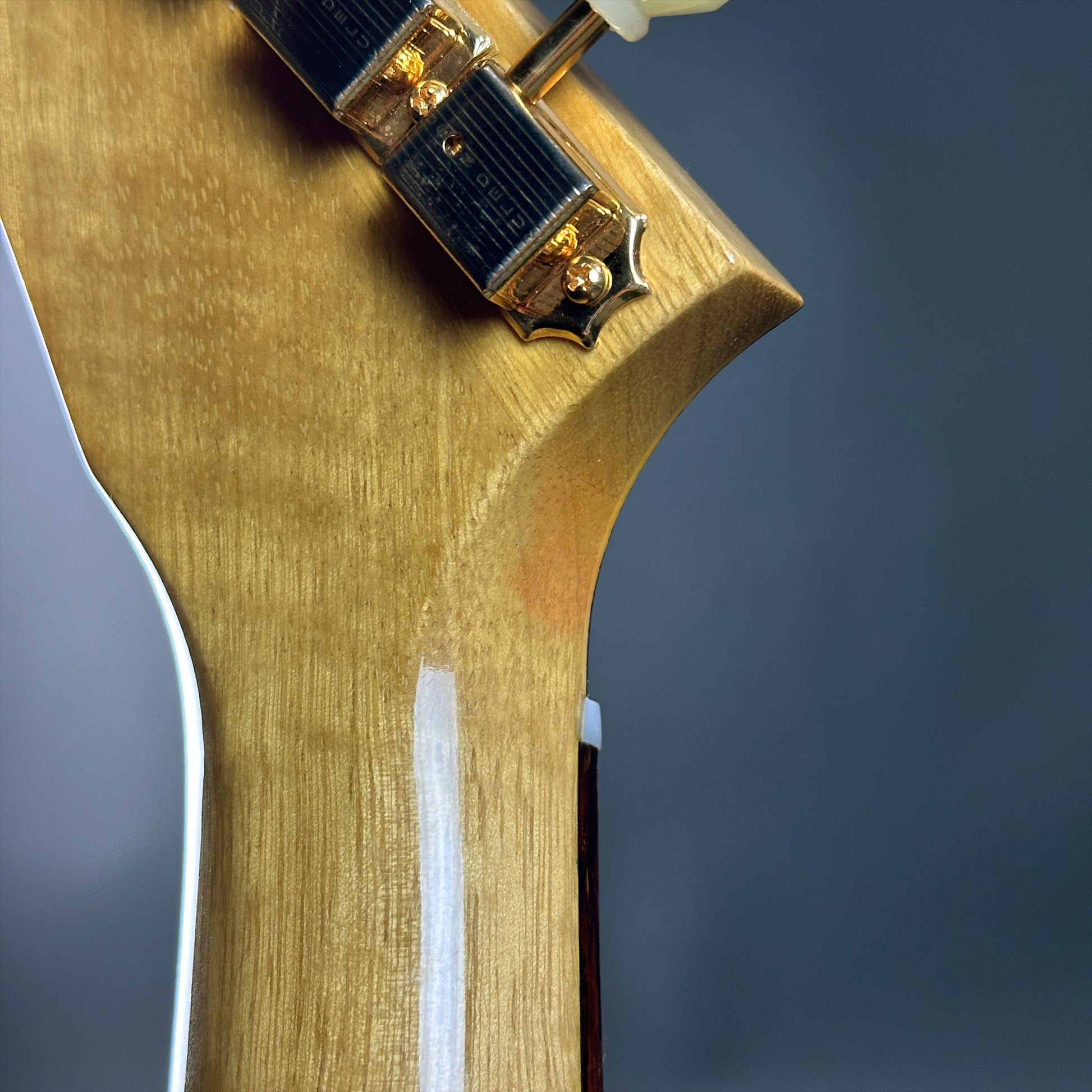 Discoloration on headstock of Used 2022 Gibson Custom Shop 1958 Explorer Reissue Korina Black Pickguard.