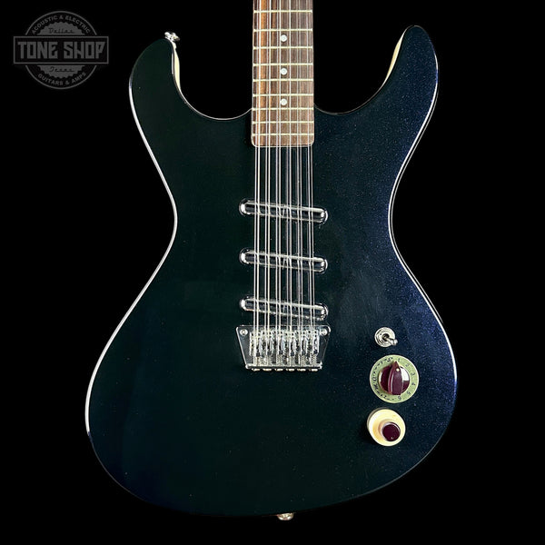 Black electric guitar with a 'Tone Shop' logo in the corner