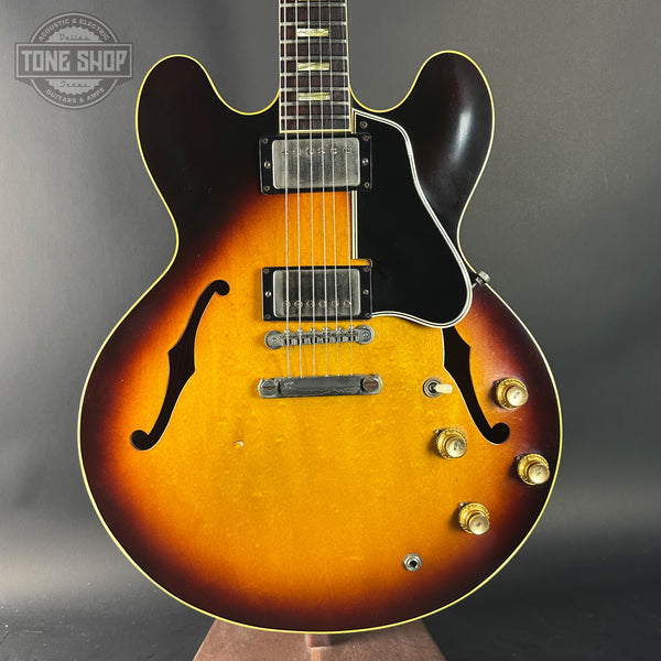 Electric guitar with a sunburst finish on a gray background, featuring the Tone Shop logo.