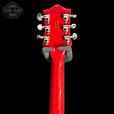 Close-up of a red guitar headstock with tuning pegs on a black background, featuring 'Tone Shop' logo.