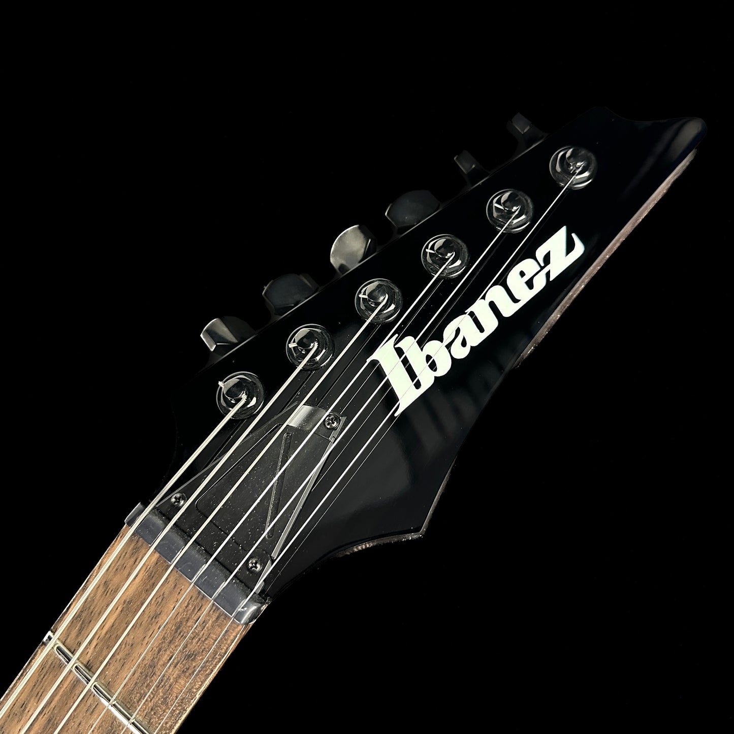 Front of headstock of Used Ibanez RGD61ALAMTR Axion Label Midnight Tropical Rainforest.