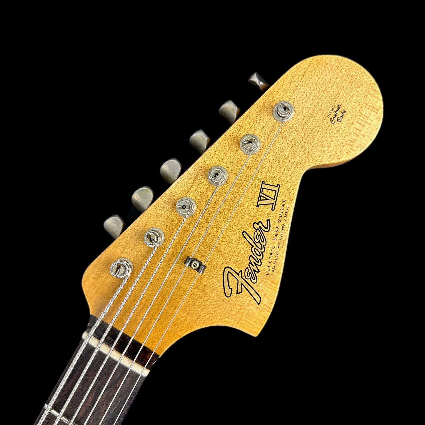 Front of headstock of Fender Custom Shop Limited Edition Bass VI Journeyman Relic Aged Aztec Gold.
