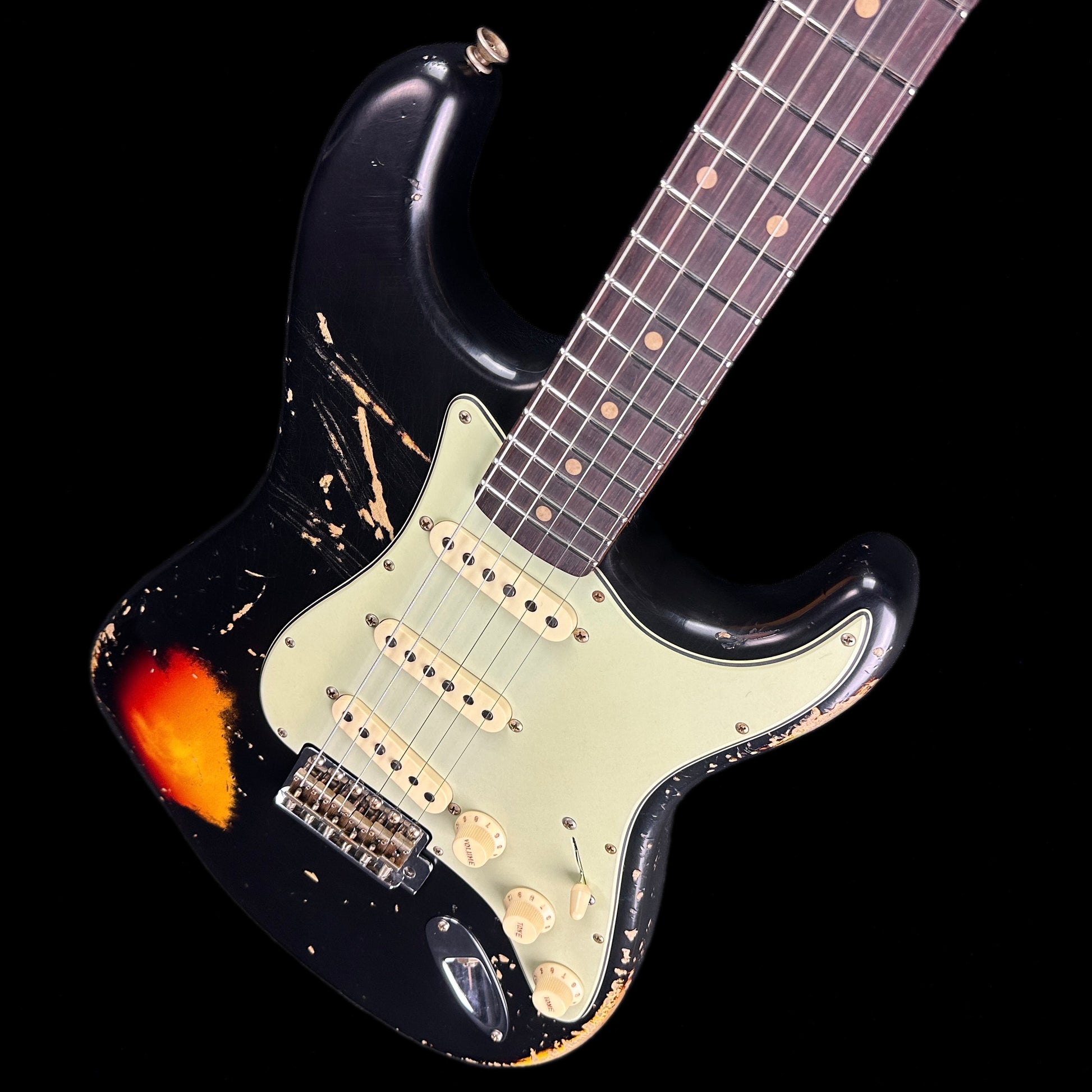 Front angle of Fender Custom Shop Limited Edition '62 Strat Heavy Relic Aged Black Over 3 Color Sunburst.