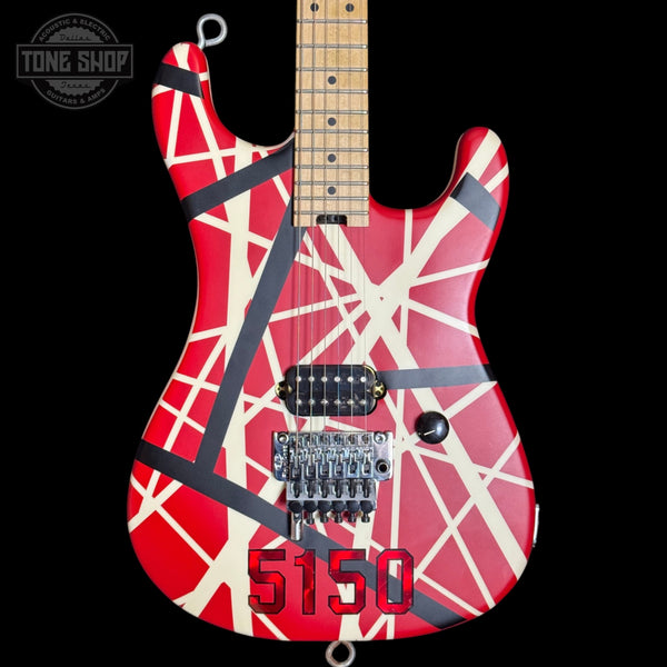 Guitar with red and white design on a black background, featuring the 'Tone Shop' logo.