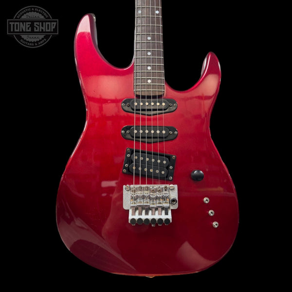 Red electric guitar on a black background with 'Tone Shop' logo.