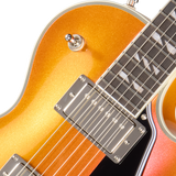 Close-up of a sunburst electric guitar with a white pickguard on a white background