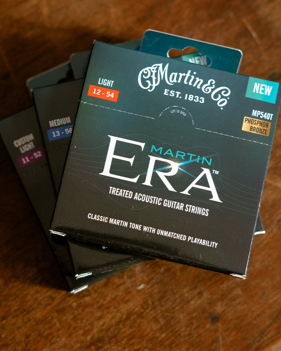 Martin Era Strings in green packaging on a wooden background