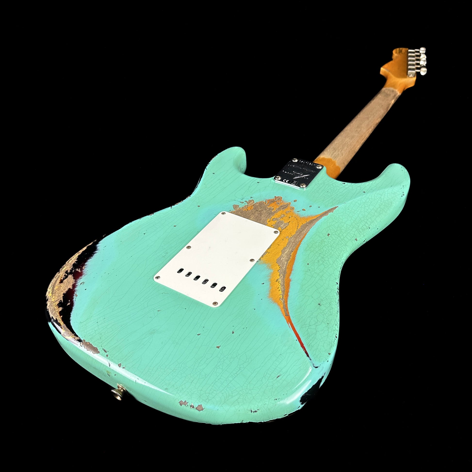Back angle of Fender Custom Shop Limited Edition '62 Strat Heavy Relic Faded Aged Sea Foam Green Over 3 Color Sunburst.
