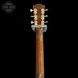 Close-up of a guitar headstock with tuning pegs on a black background, featuring the Tone Shop logo.
