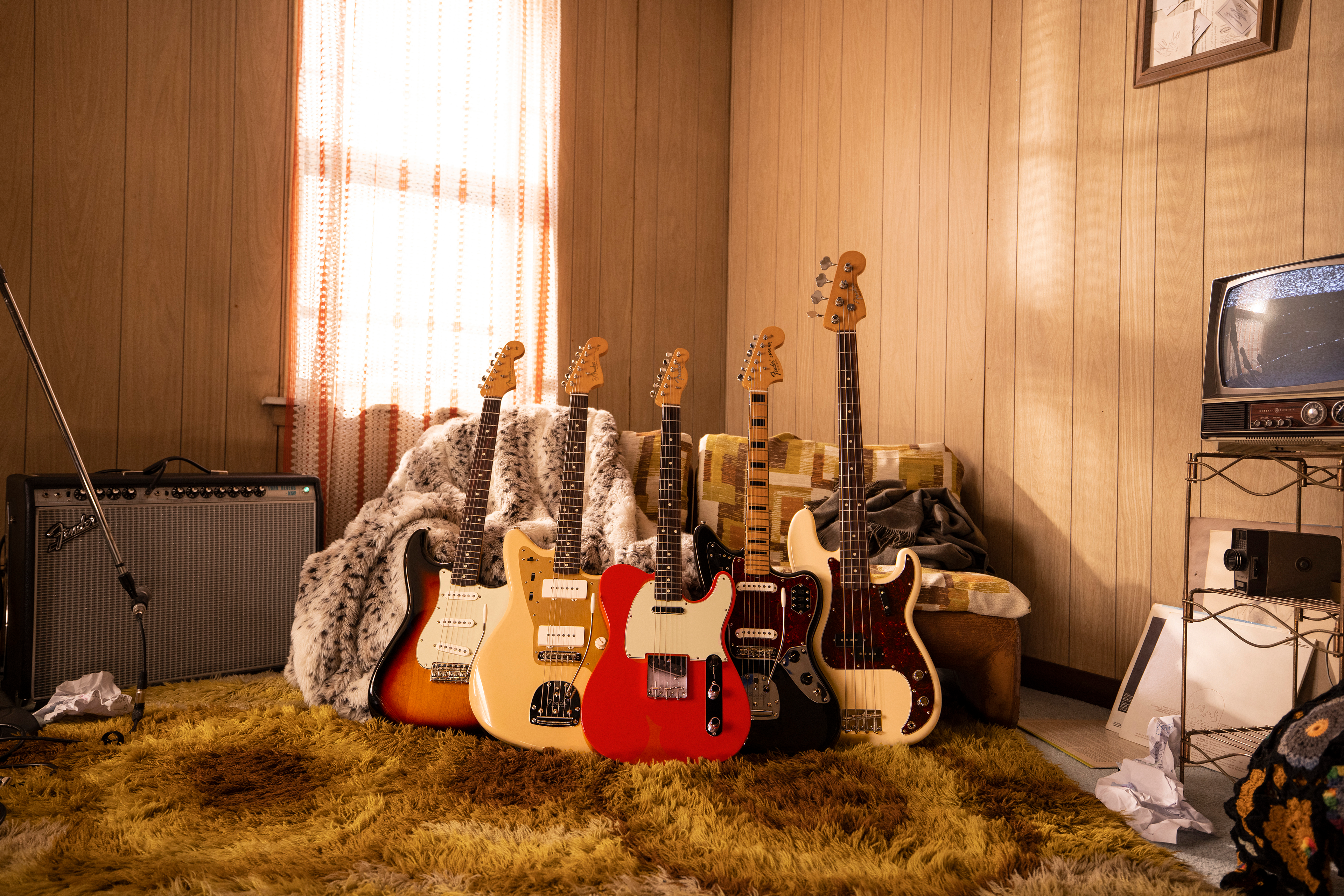 A group of Fender guitars on a shag rug. 