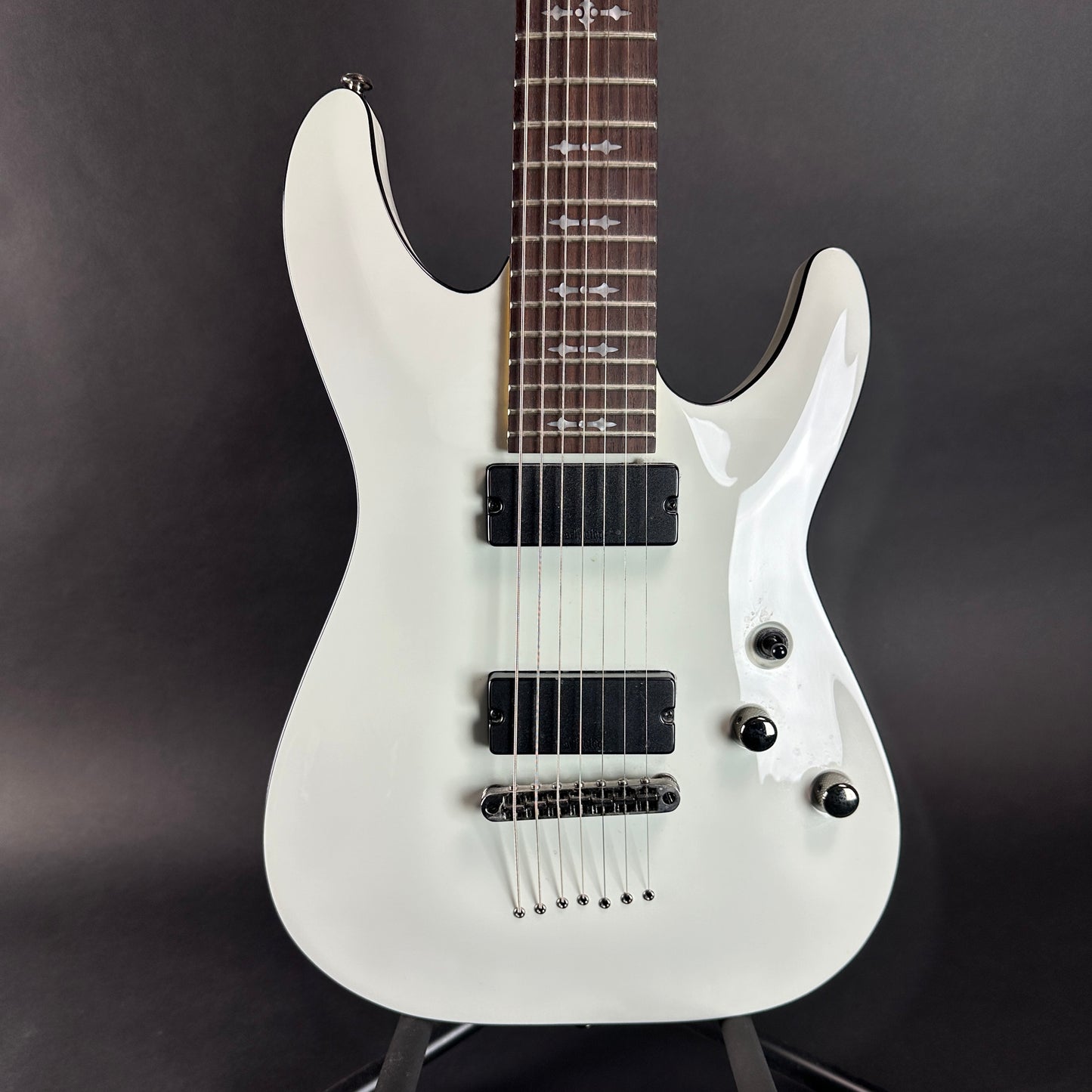 Front of body of Used Schecter Demon 7 Vintage White.