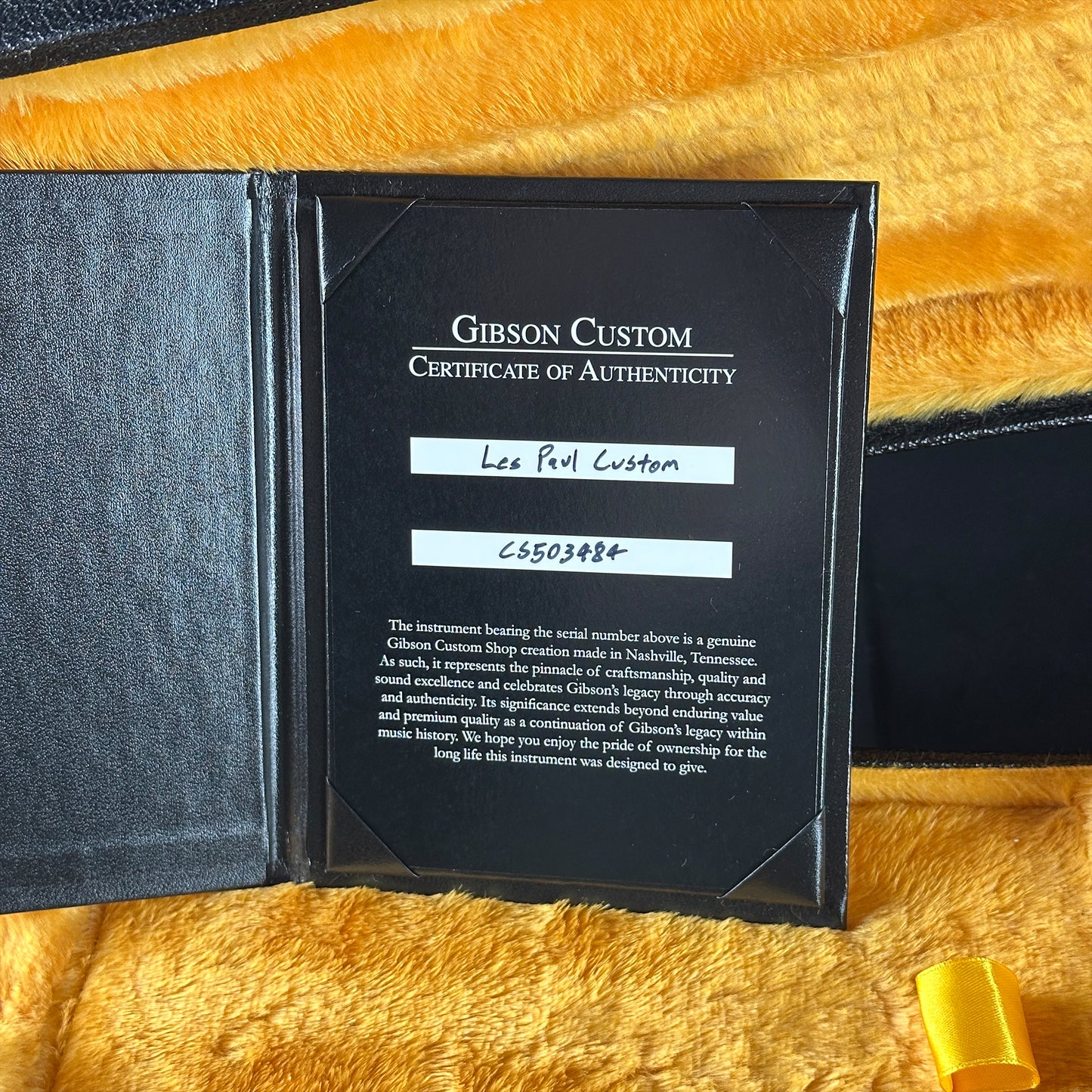 Gibson Custom Certificate of Authenticity on a yellow textured surface